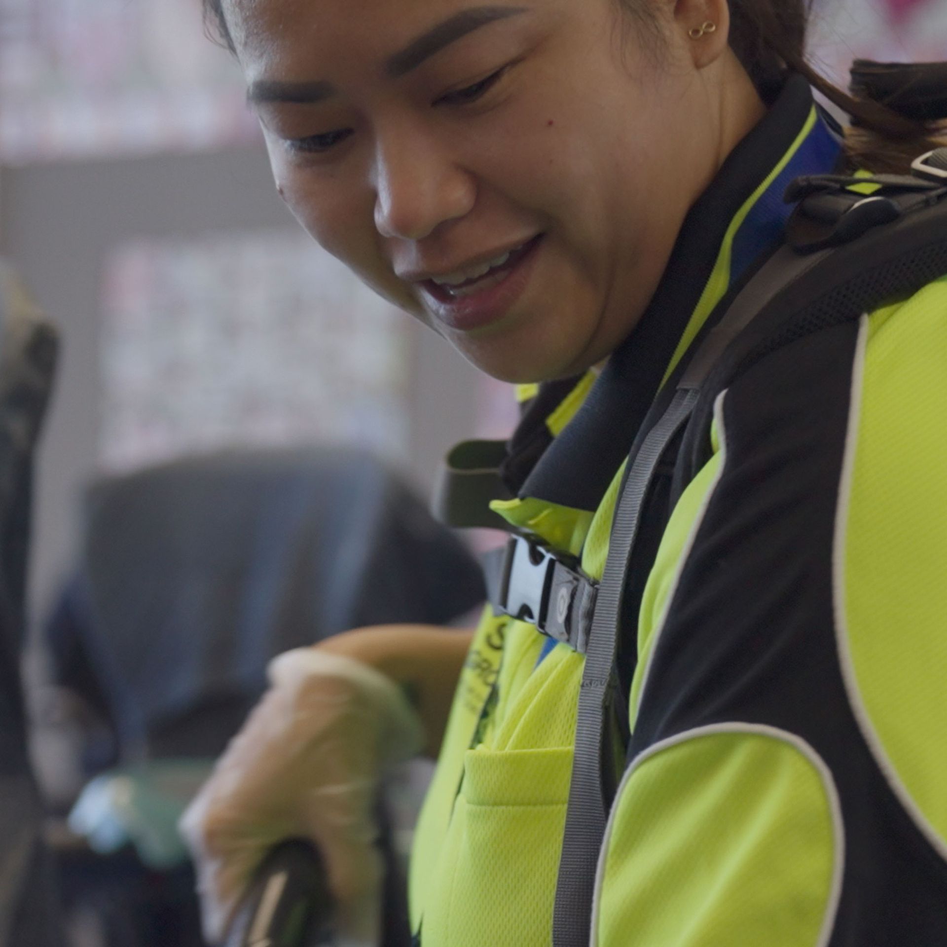 A woman wearing a yellow vest with the letter m on it