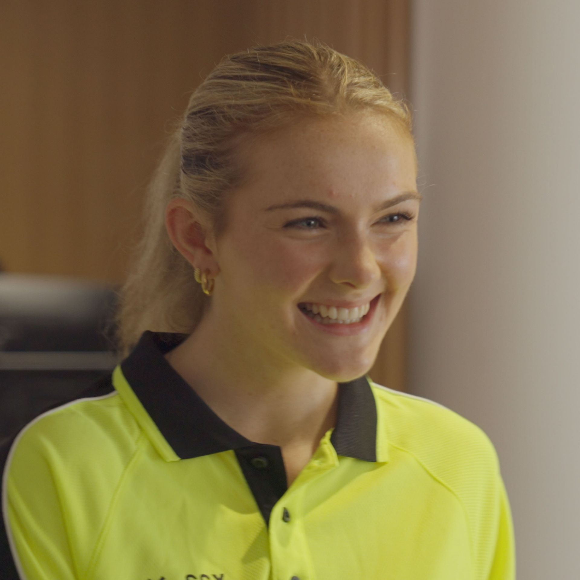 A woman wearing a yellow shirt with the word fox on it