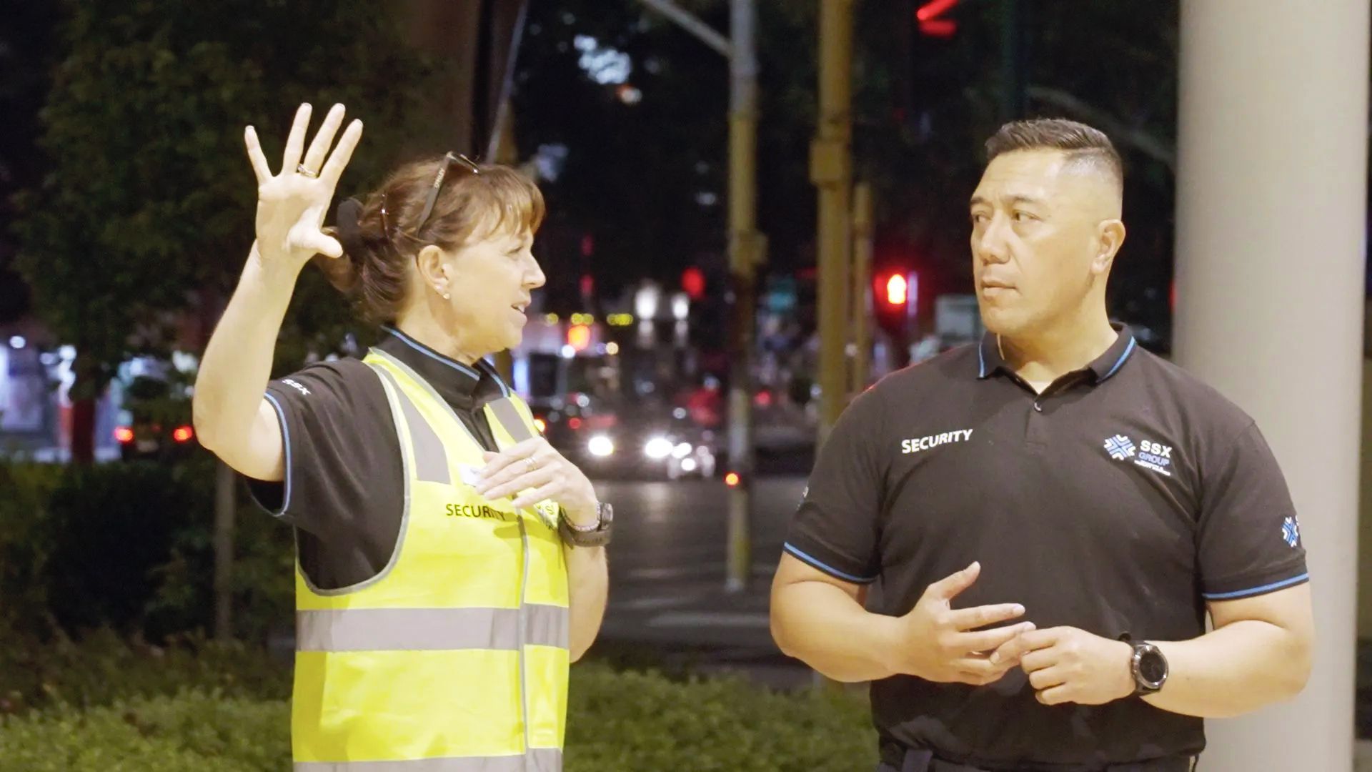 A man and a woman are standing next to each other on a city street.
