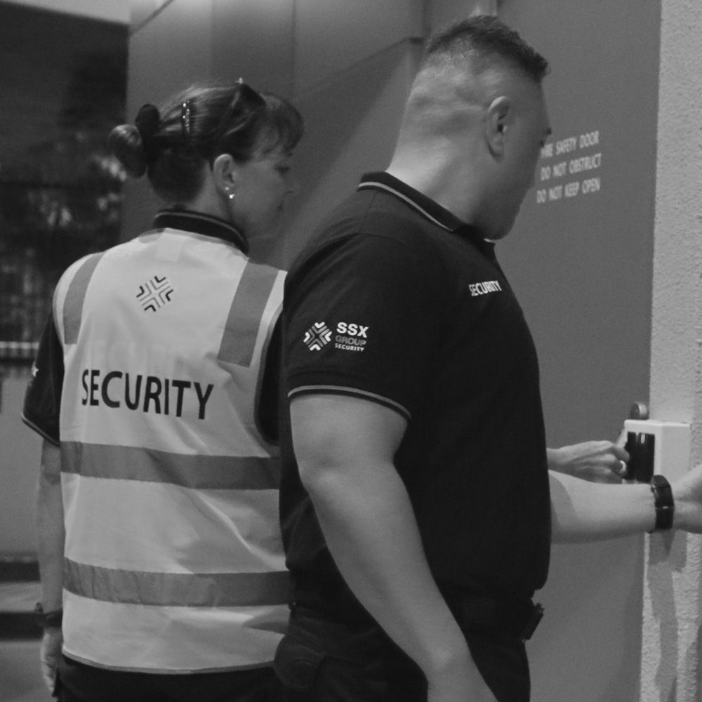 A black and white photo of two security guards