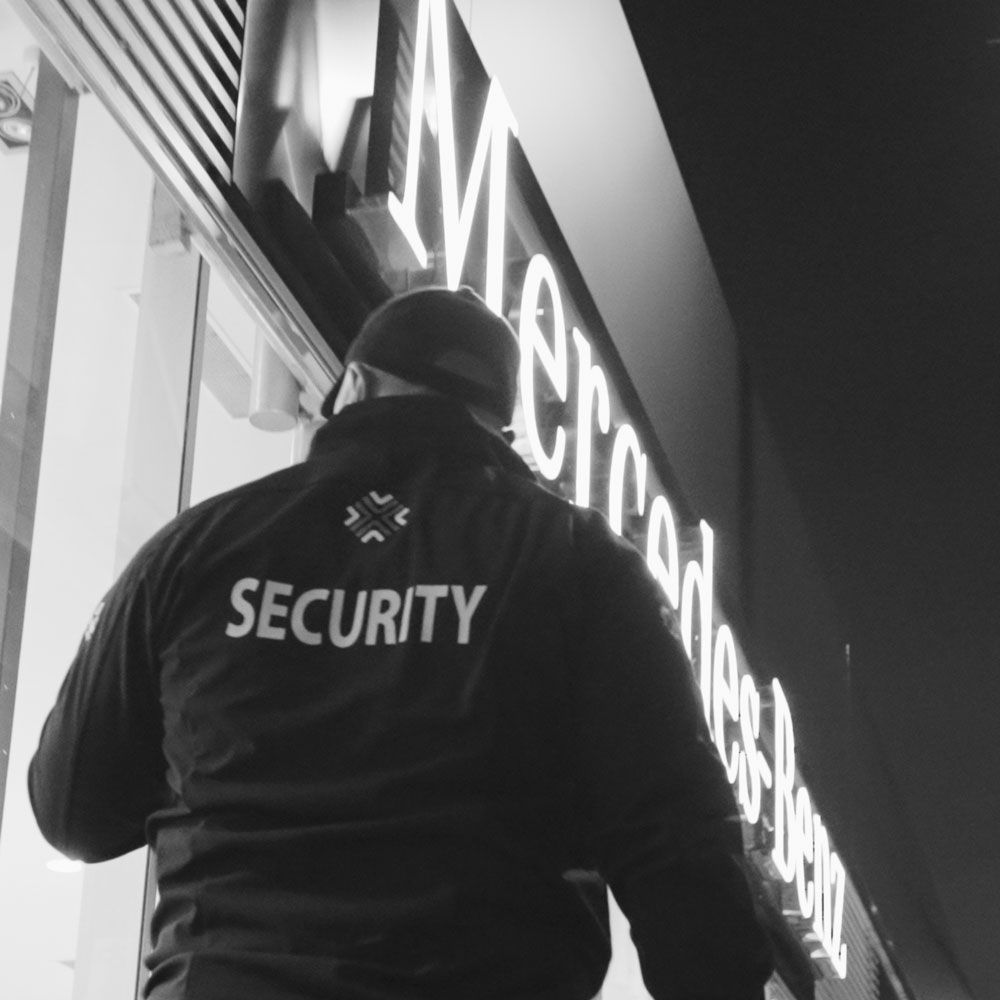 A security guard stands in front of a mercedes benz sign