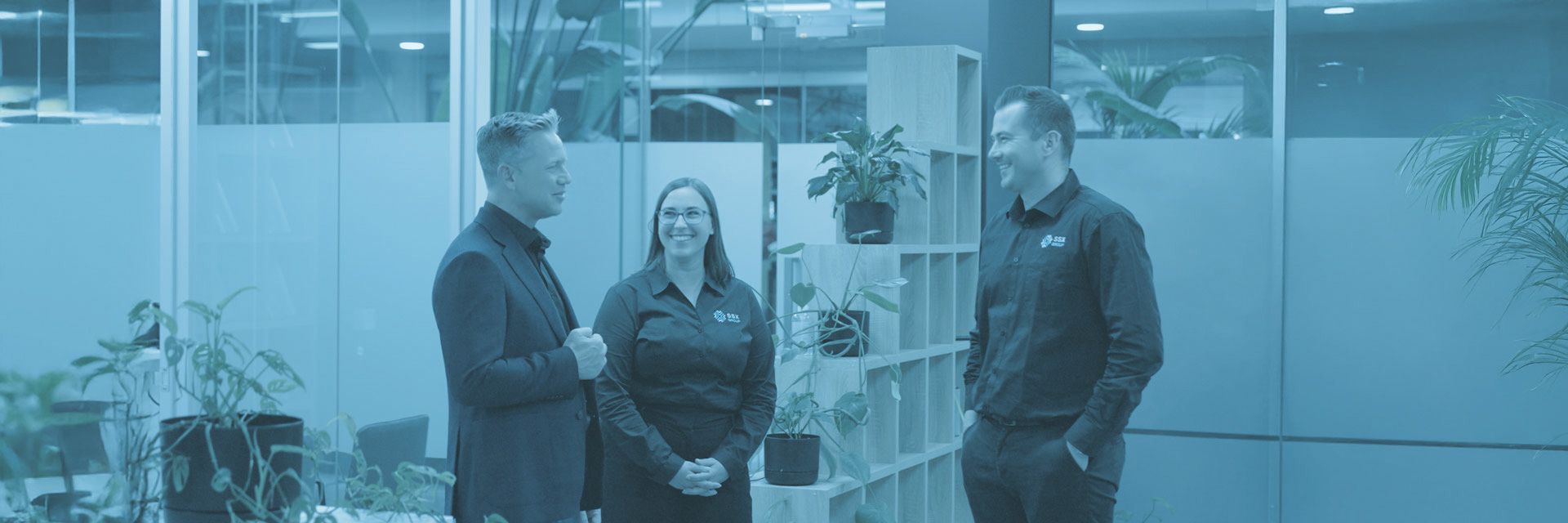 A group of people are standing next to each other in an office.