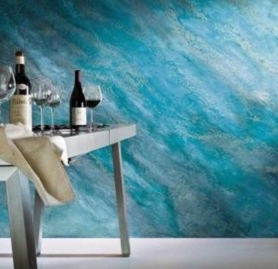 sala da pranzo con parete azzurra e grigia effetto acqua