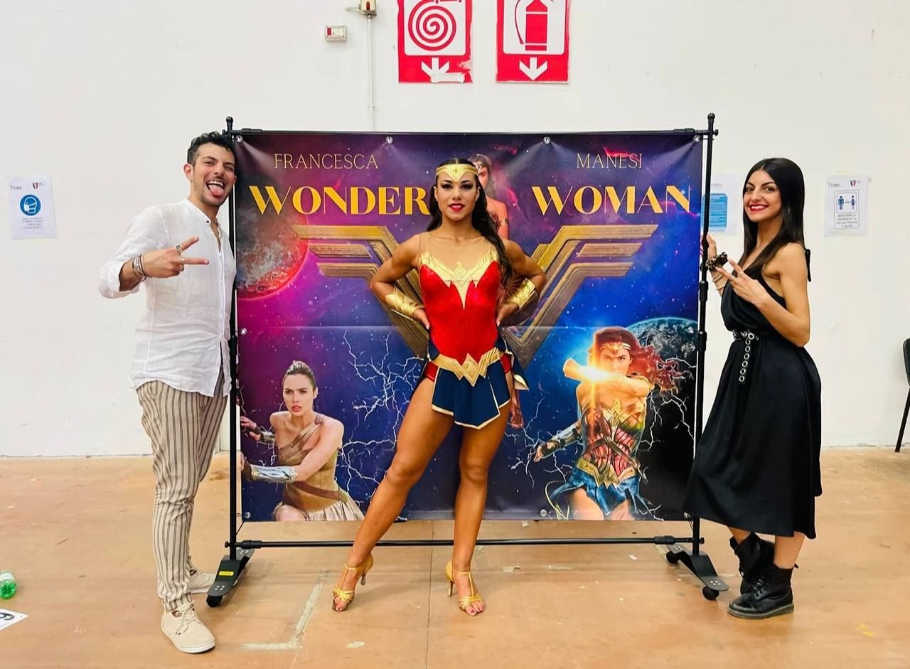 Tre persone posano davanti a uno sfondo di 