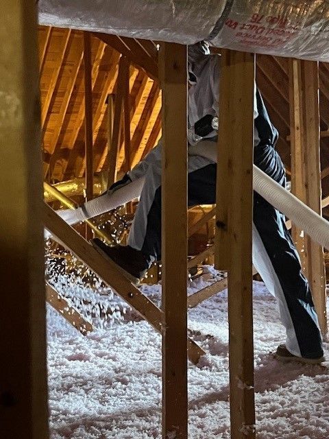 A person is working in the attic of a house.