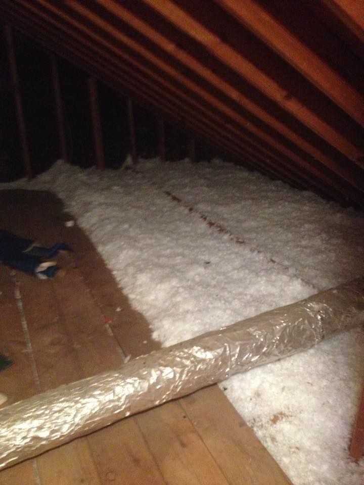 An attic with a lot of insulation on the floor.