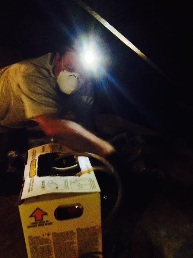 A man wearing a mask is working on a box.