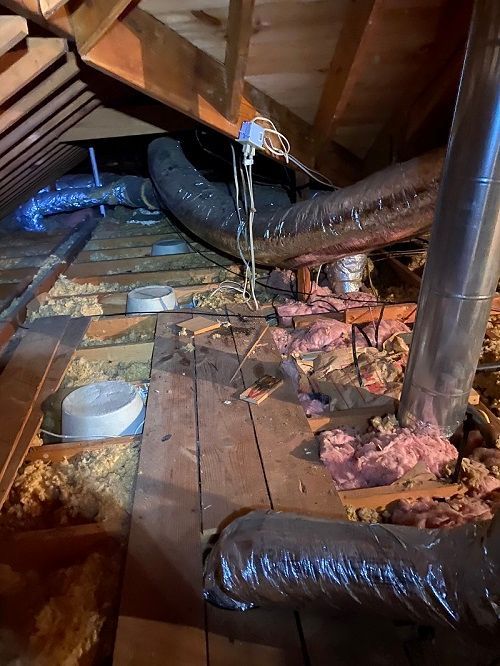 An attic with a lot of ducts and insulation.