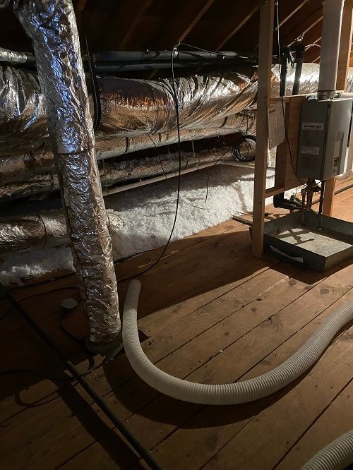 There is a vacuum hose in the attic of a house.