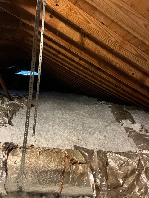 An attic with a measuring tape hanging from the ceiling.