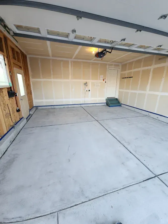 Empty garage interior with concrete floor and unfinished walls.