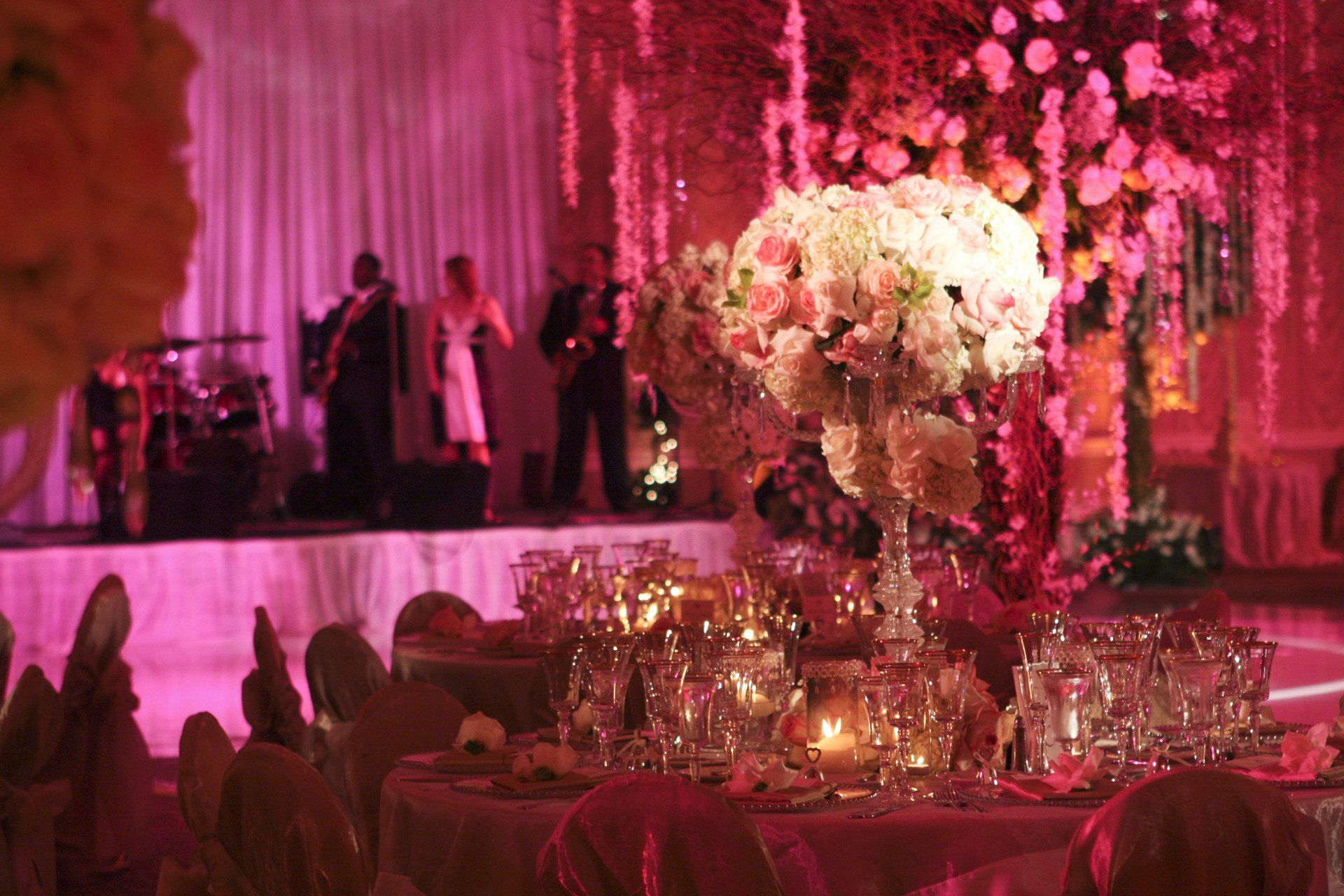 A wedding reception with tables and chairs set up and a band on stage.
