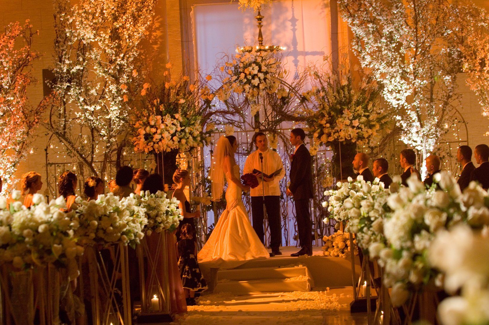 A bride and groom are getting married in a church surrounded by flowers.