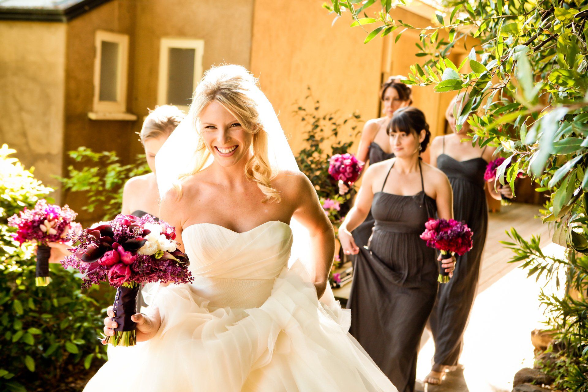 A bride and her bridesmaids are walking down a path