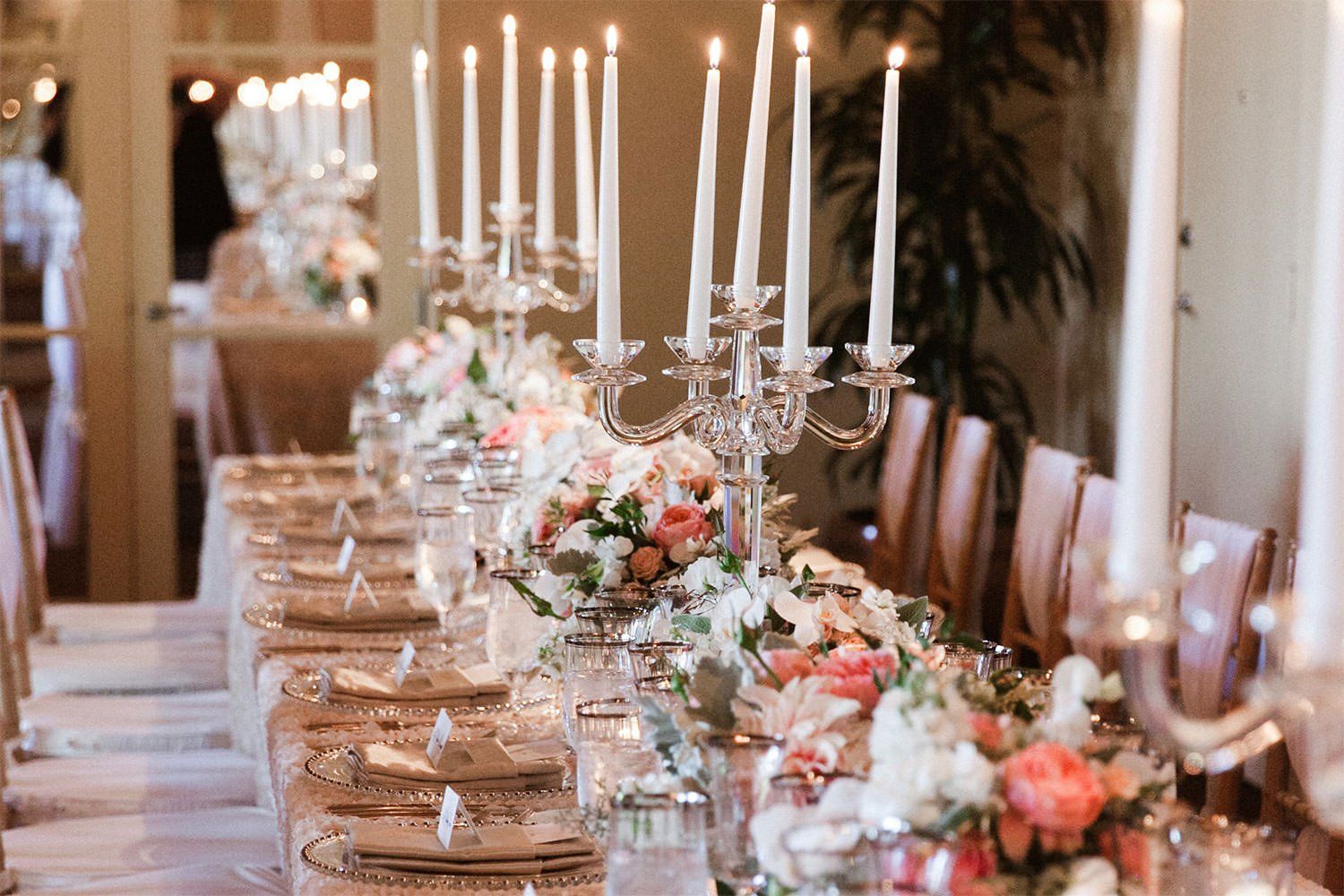 A long table with candles and flowers on it.
