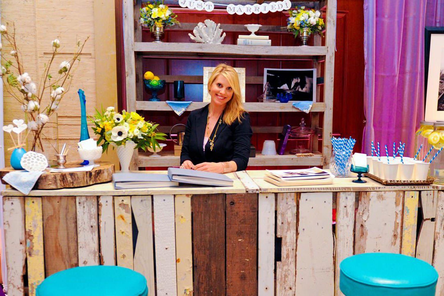 A woman is standing behind a wooden counter.