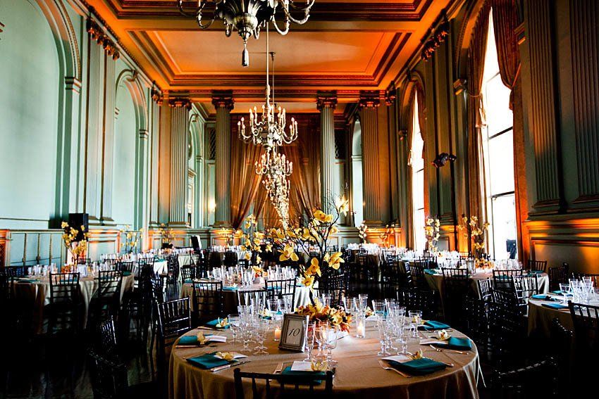 A large room with tables and chairs set up for a wedding reception
