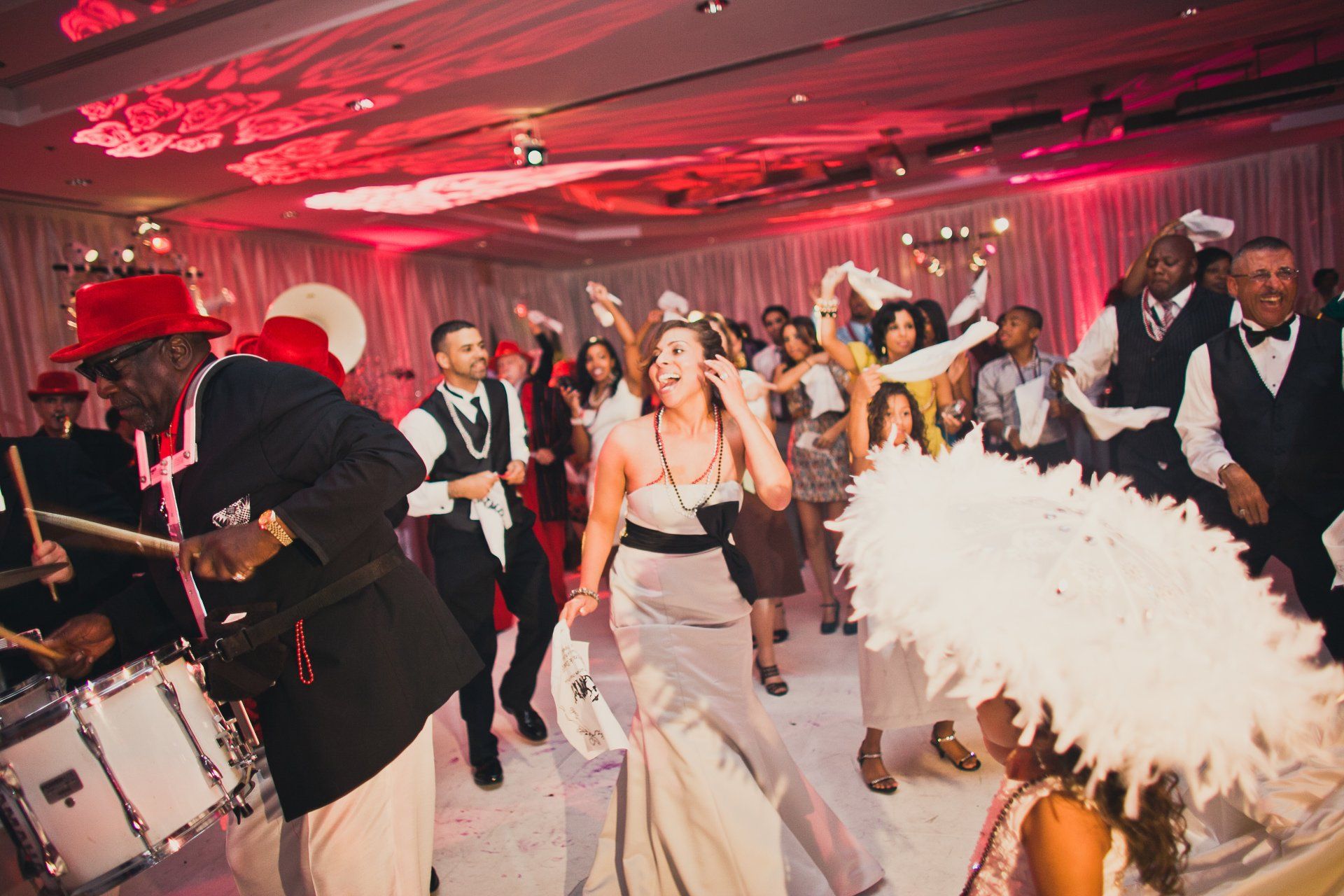 A group of people are dancing in a room at a wedding reception.