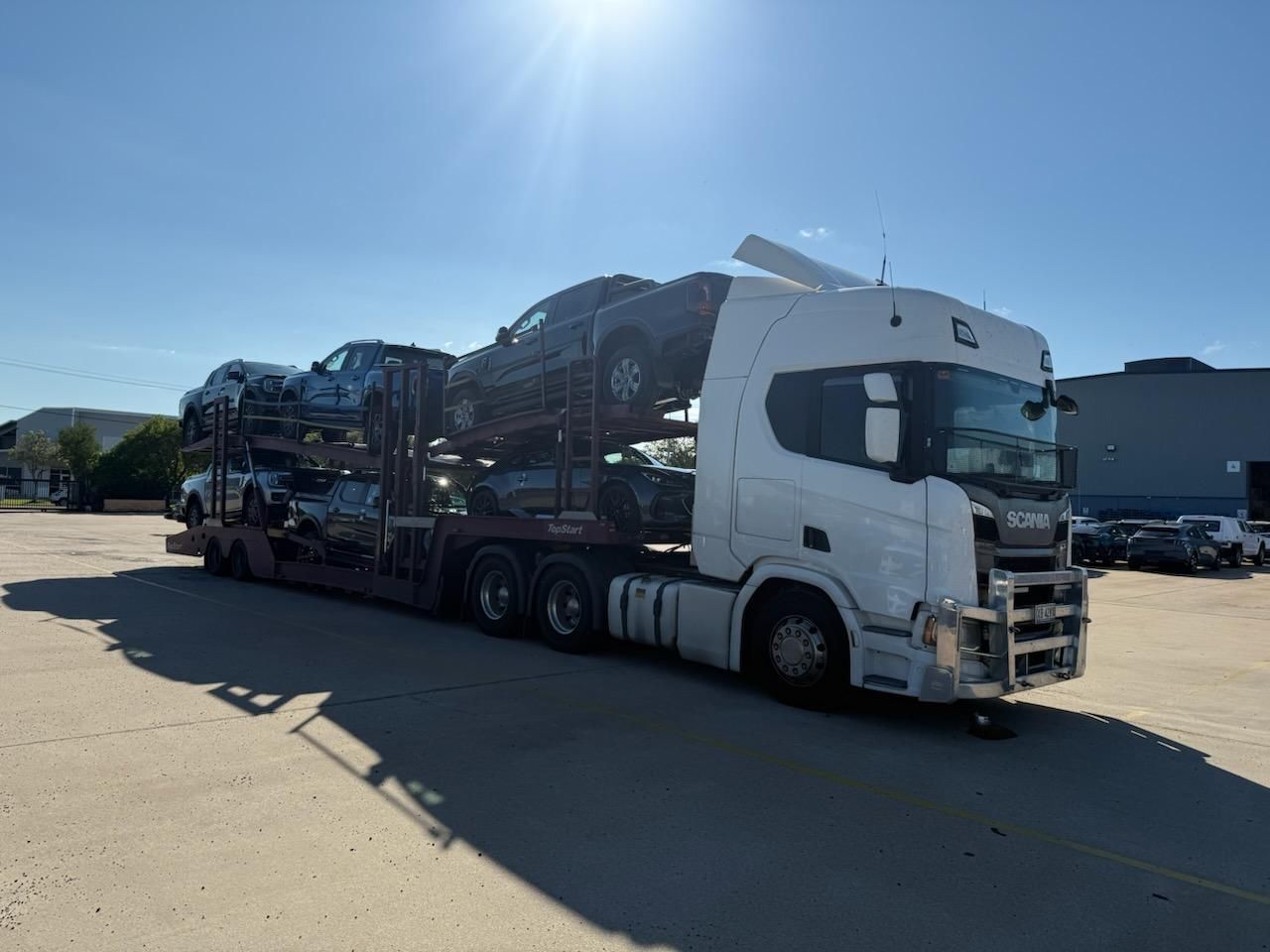 Car carrier truck loaded with several vehicles parked on a sunny lot — Alfie's Towing in Coen, QLD