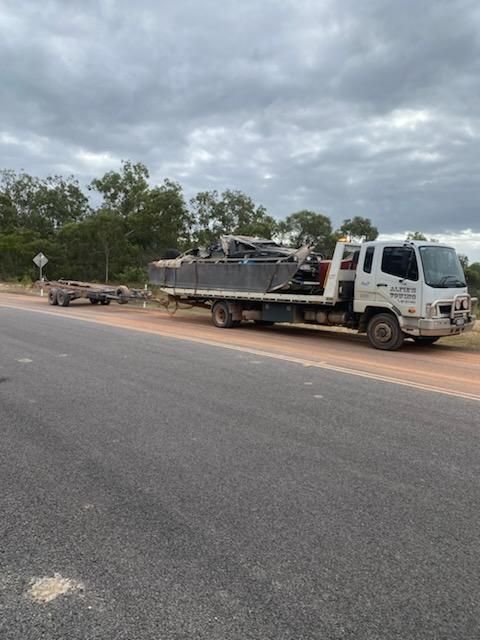 A Flatbed Truck Carrying Heavy Items Parked on the Side of a Road — Alfie's Towing in Bentley Park, QLD