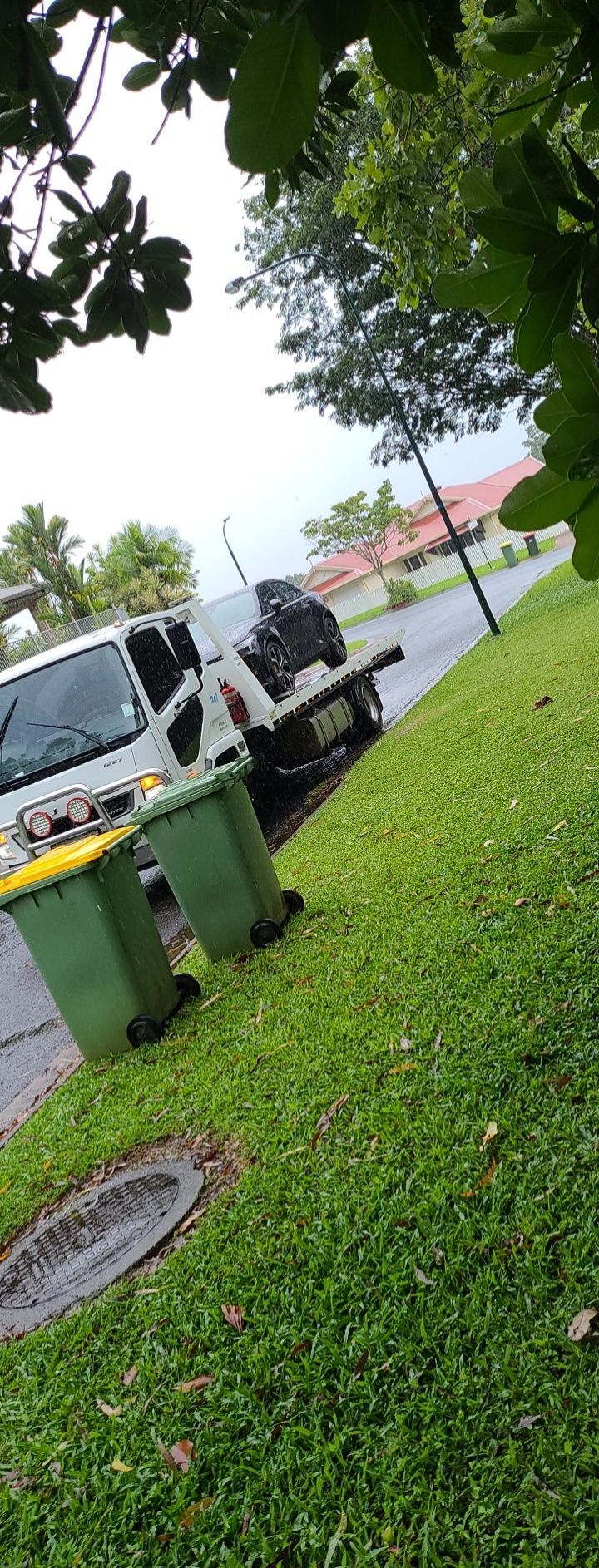 A White Van is Parked Next to Green Recycling Bins on a Grassy Curb — Alfie's Towing in Coen, QLD