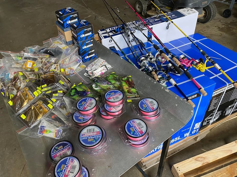 A Table Filled With Fishing Rods And Other Fishing Equipment — Posties Caravans Boats Small Engines Inverell In Inverell, NSW