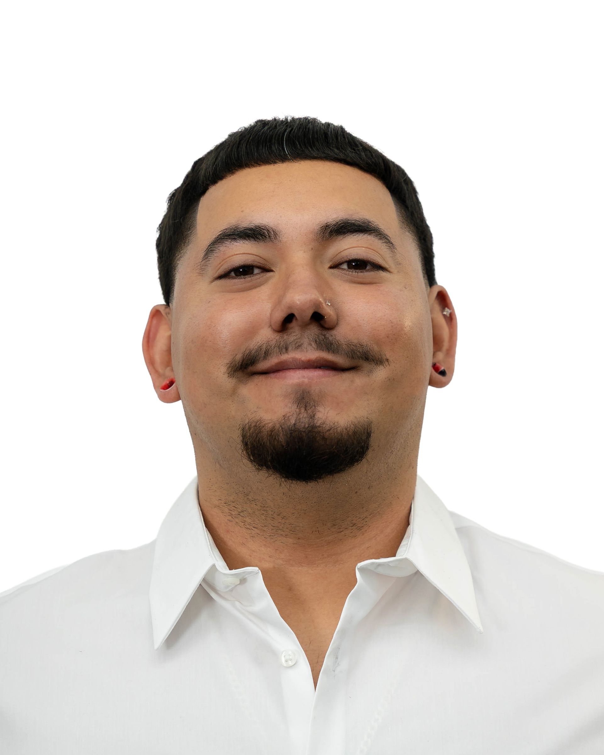Man with dark hair and goatee, wearing a white collared shirt, smiling.