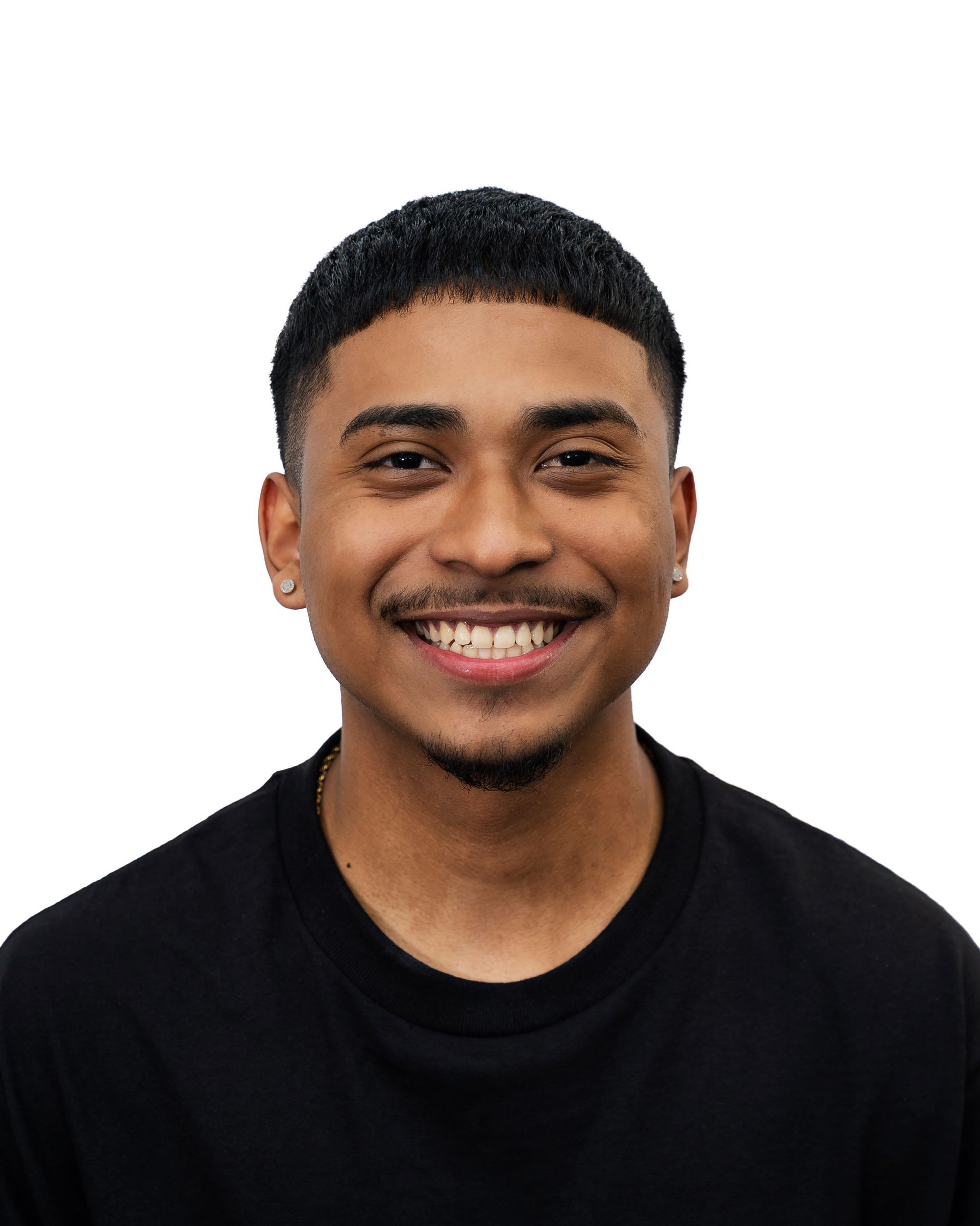 Smiling person with dark hair, wearing a black shirt, against a white background.