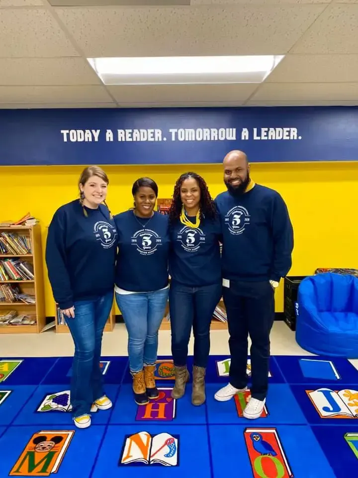 A group of people standing in front of a sign that says today a reader tomorrow a leader