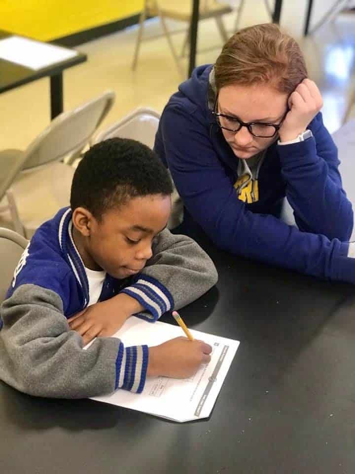 A woman is helping a young boy with his homework.
