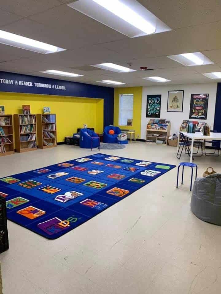 There is a large blue rug in the middle of the room.
