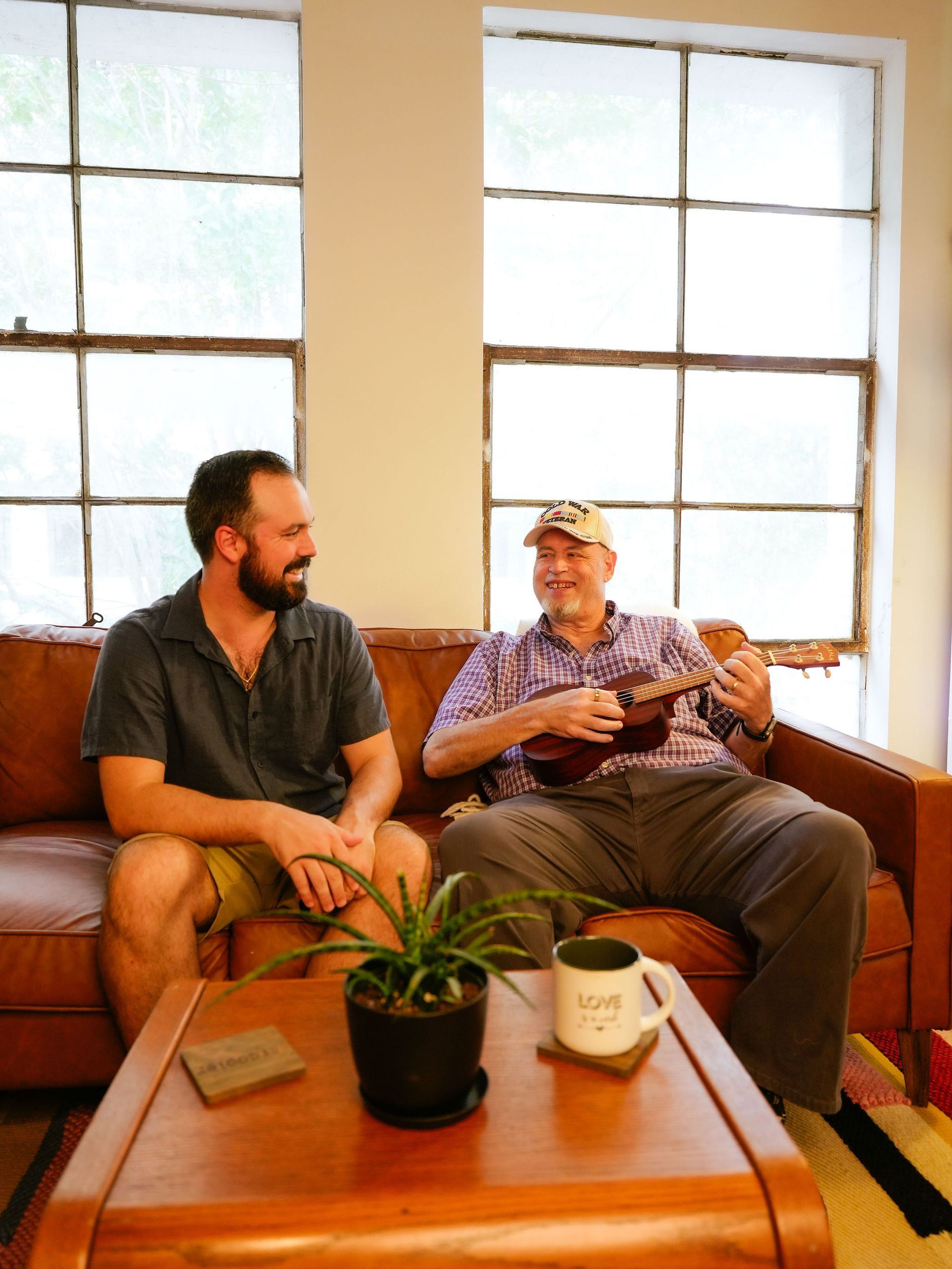 Two people assembling a blue and white jigsaw puzzle on a wooden table.