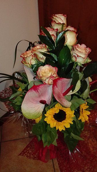Un bouquet di rose, girasoli e anthurium