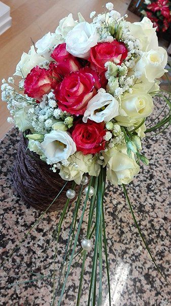 Un bouquet di rose di color fucsia, bianco e velo da sposa