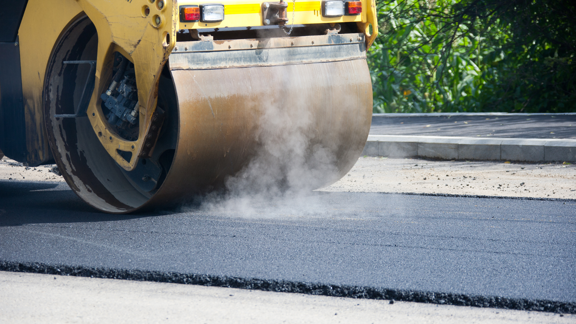A roller is rolling asphalt on a road.