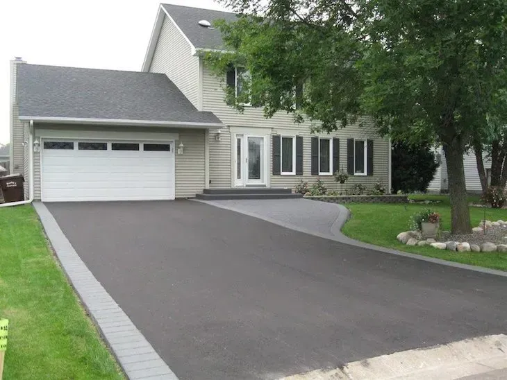 A house with a large driveway and a white garage door