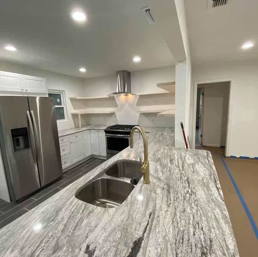 A kitchen with stainless steel appliances and granite counter tops.