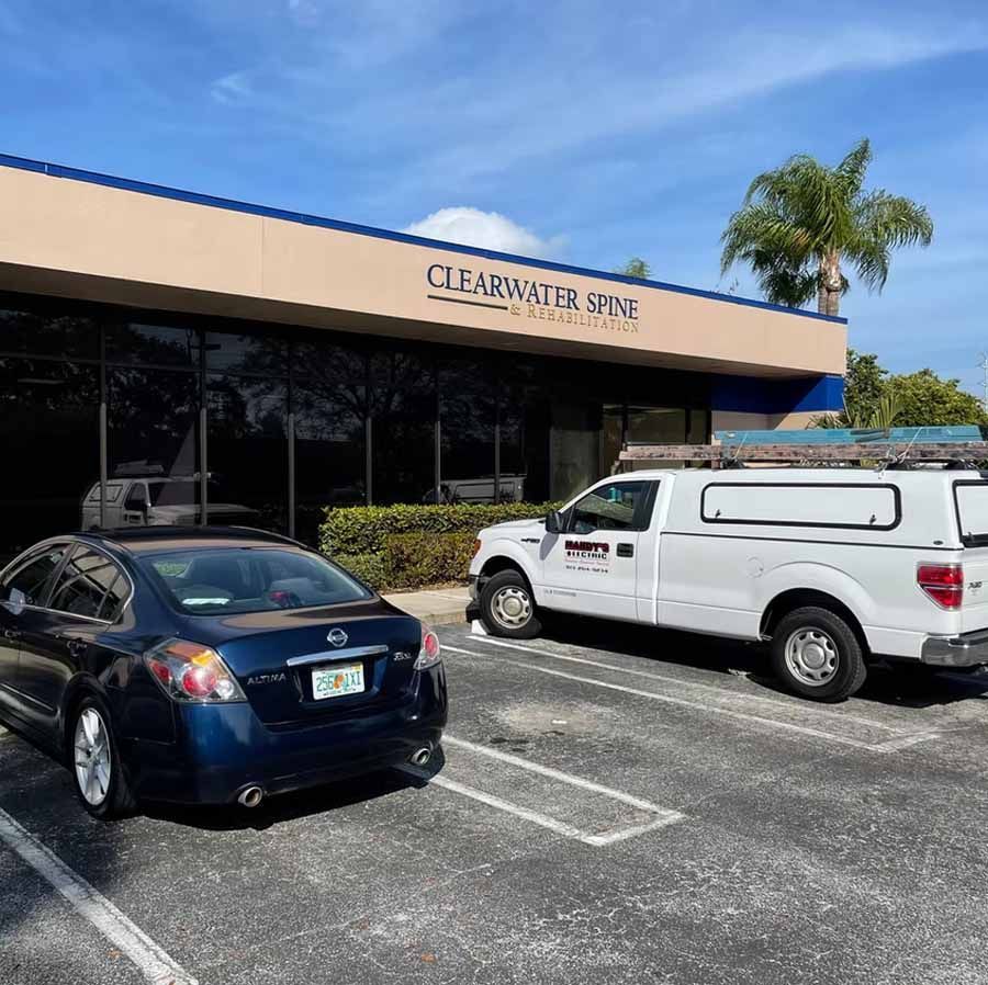 Two cars and a truck are parked in front of a building.