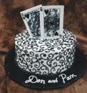 A black and white cake with playing cards on top of it.