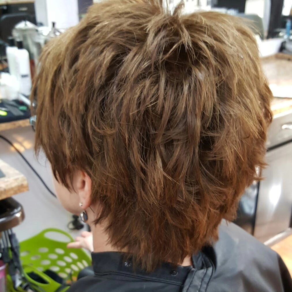 A woman is getting her hair cut in a salon