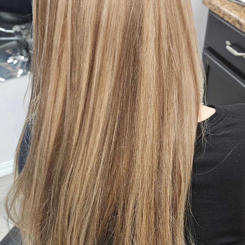 A woman with long blonde hair is sitting in a chair