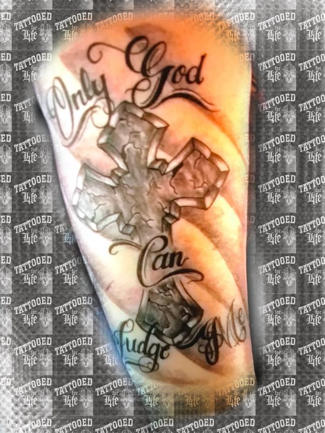 A person has a tattoo on their arm that says `` only god can judge me ''.