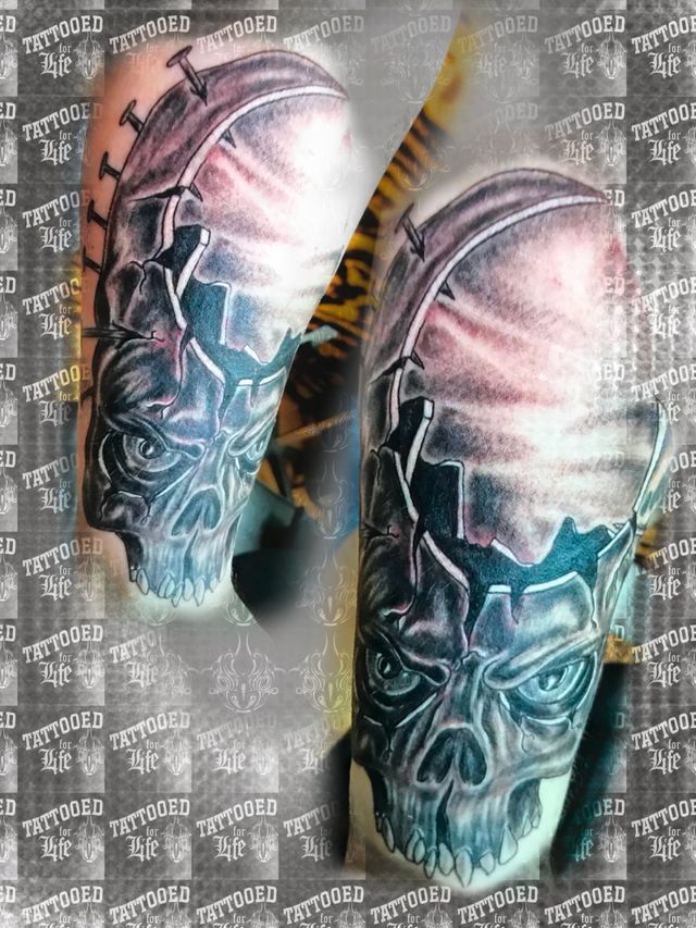 A close up of a tattoo of a skull on a person 's arm.