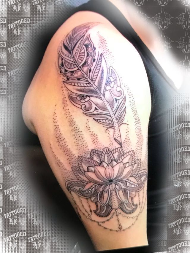 A woman has a tattoo of a feather and a flower on her arm
