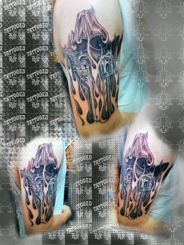 A tattoo of a skull with flames on a person 's arm.