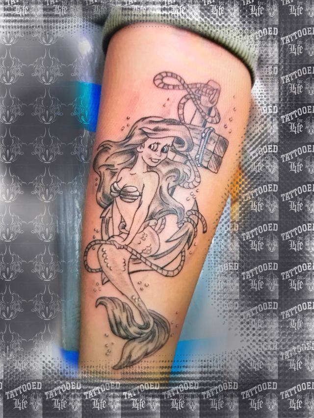 A woman has a tattoo of a mermaid on her leg