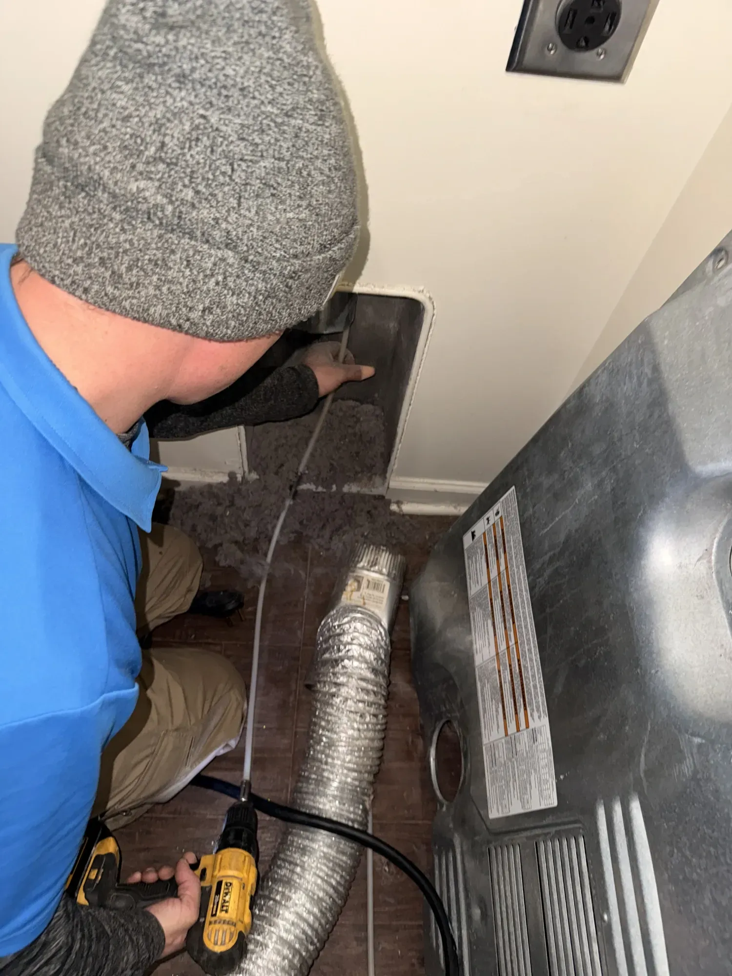 Two industrial dryers with blue laundry, a white wire basket in front.