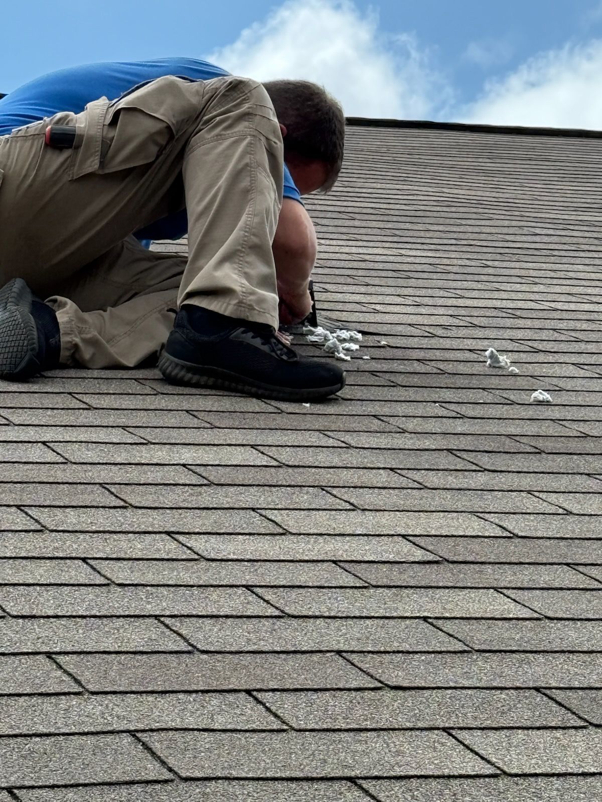 A metal vent pipe with a peaked top is mounted on a textured, dark wall; a strong shadow is cast to the left.