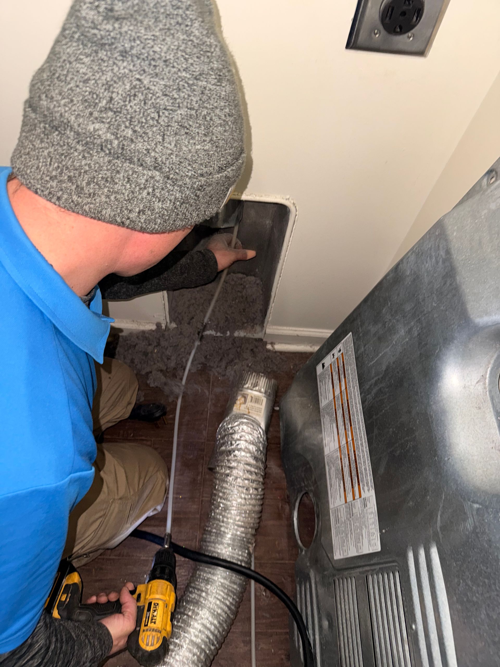 Laundry room with washing machines, a trash can, and a clock.