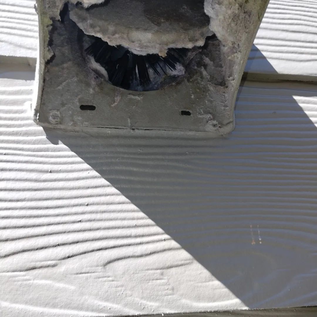 Beige rooftop ventilation system against a bright blue sky.